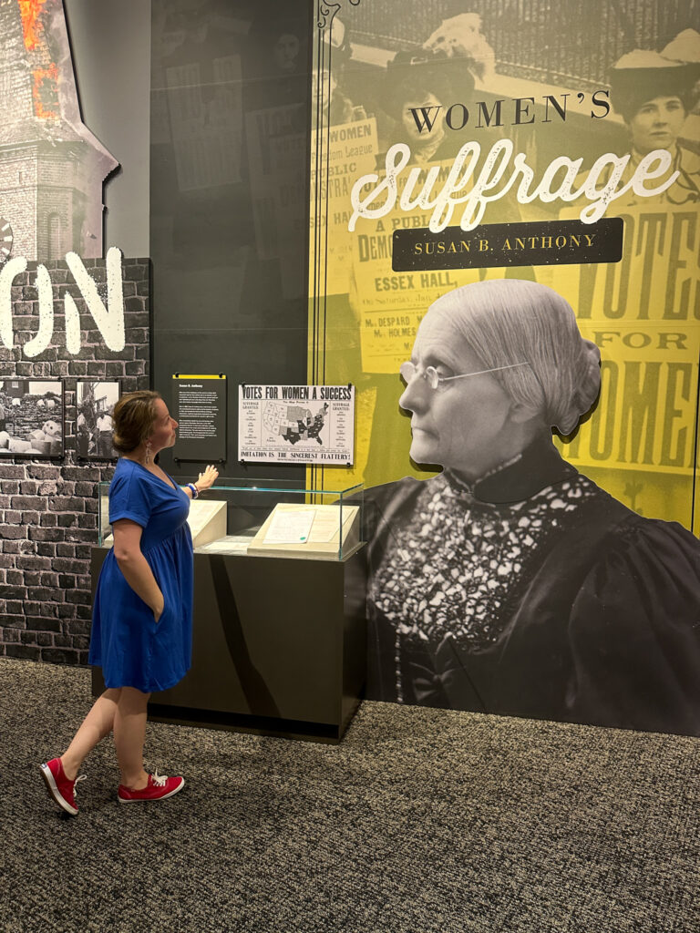 woman looks at large mural of Susan B. Anthony
