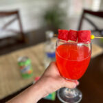 watermelon lemonade vodka in a glass in lady's hand
