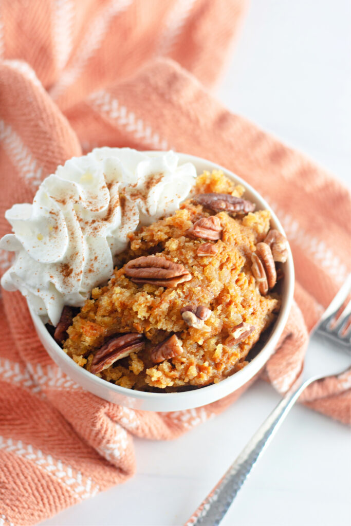 crockpot pumpkin cobbler with cake mix in white bowl with orange towel at back