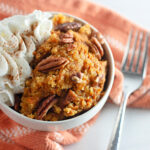 Crockpot pumpkin pecan cobbler with cake mix in white bowl with fork beside