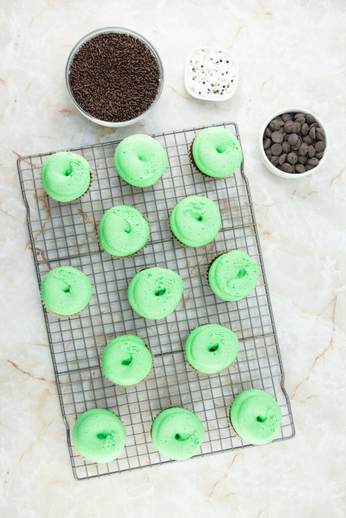 chocolate cupcakes with green icing on wire rack 