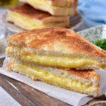 cut air fryer grilled cheese toastie on a brown wooden board