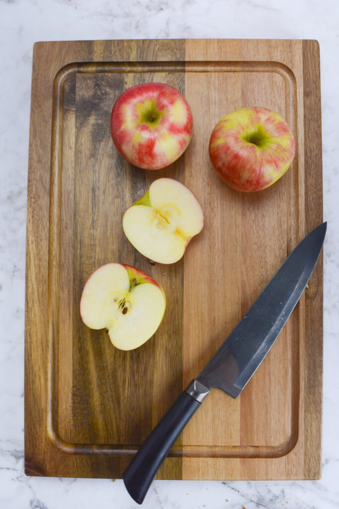 wooden tray with honey crisp and a large knife