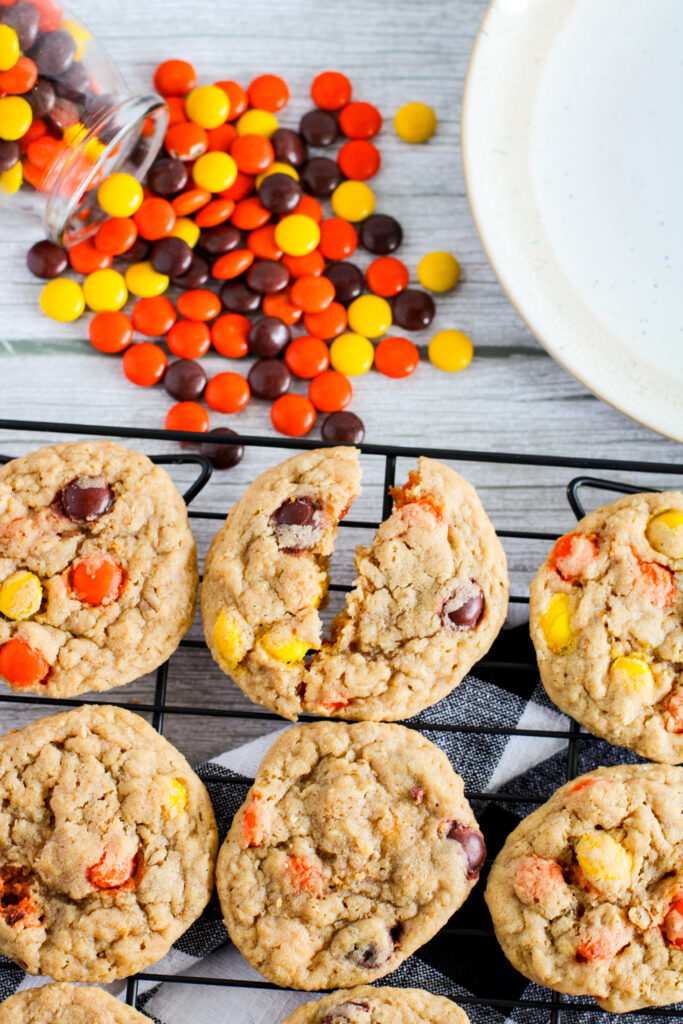 wire rack of Reese's Pieces peanut butter cookies with candies piled at back