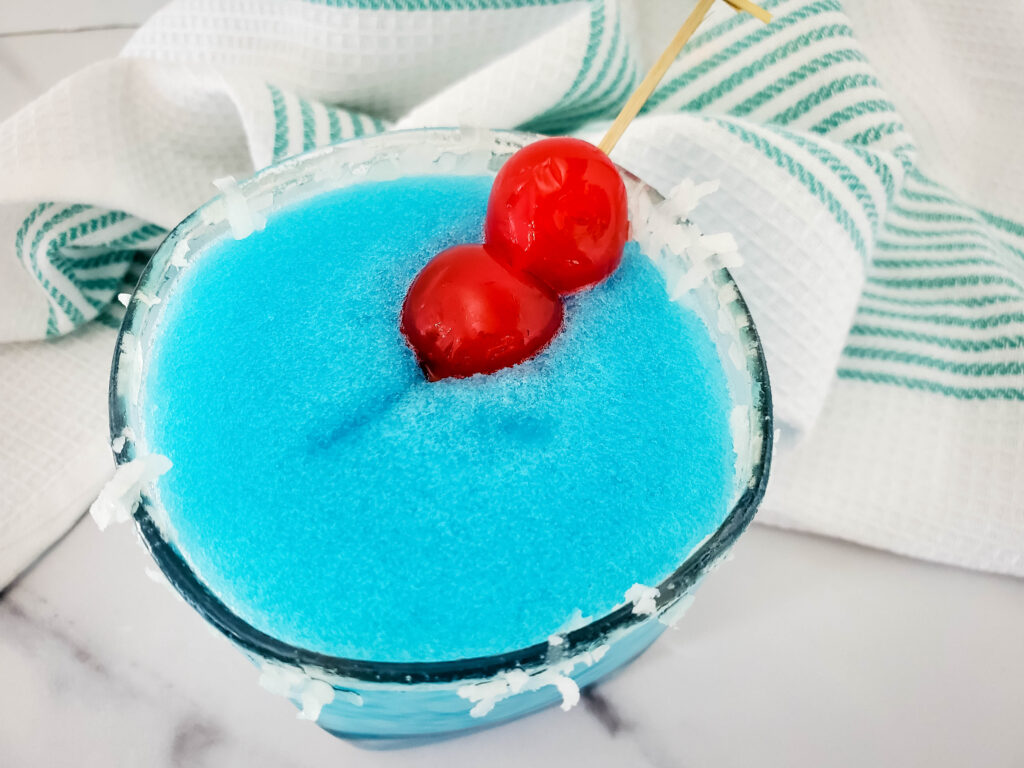 blue blended holiday cocktail with rum and a cherry on top for a blue winter cocktail
