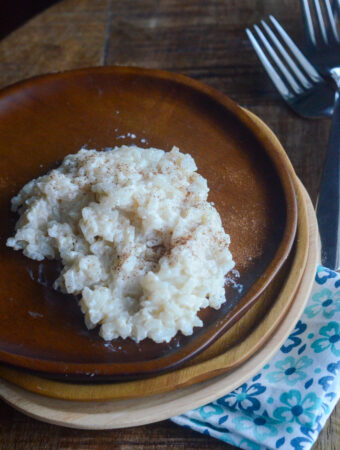 panameno arroz con lechera on wood stack of plates with flower napkin