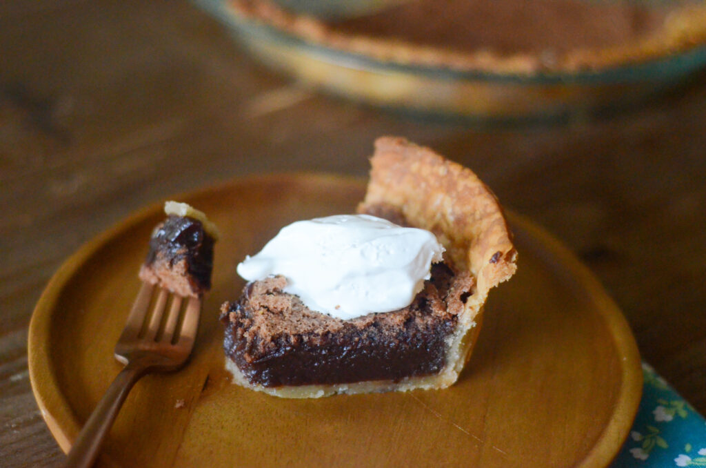 side view of chocolate chess pie with bite on top of fork
