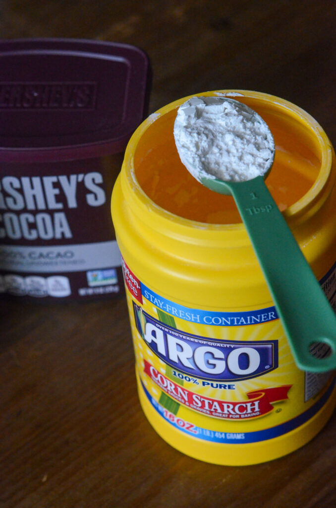 corn starch on measuring spoon on top of container