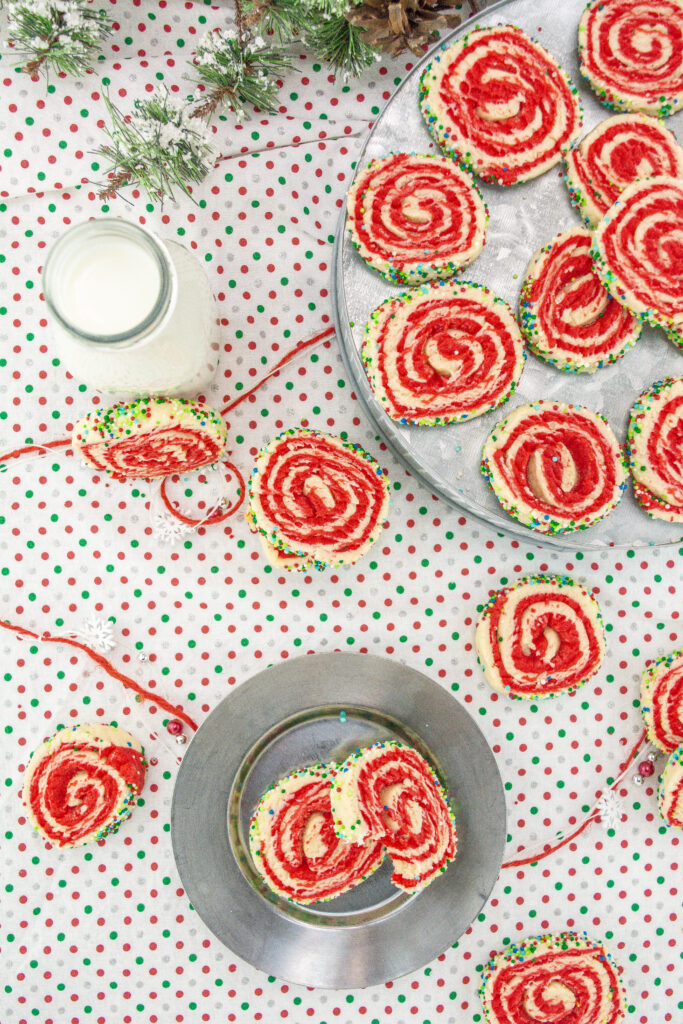 Christmas pinwheel cookies - swirled sugar cookies - on polk dot background with glass of milk