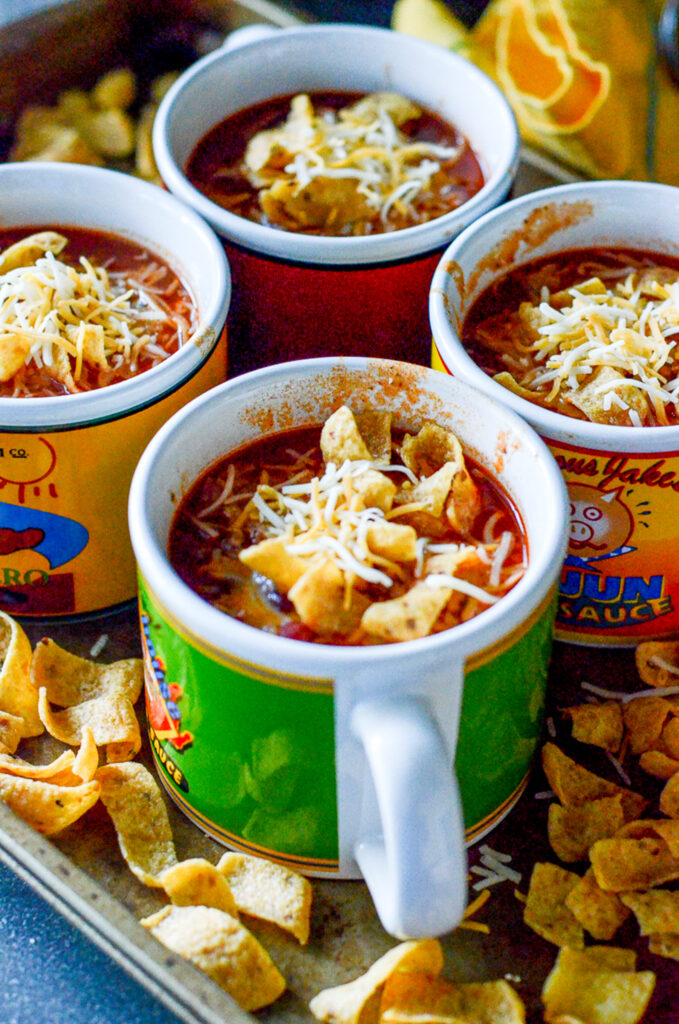 easy stove chili served in colorful soup cups with Fritos scattered around