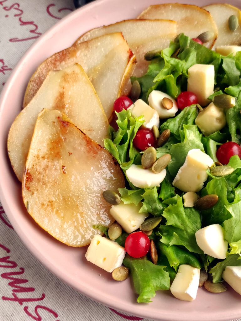 pear salad with brie and mozzarella on pink plate