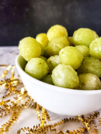 green sugared grapes in champagne in a serving bowl with confetti