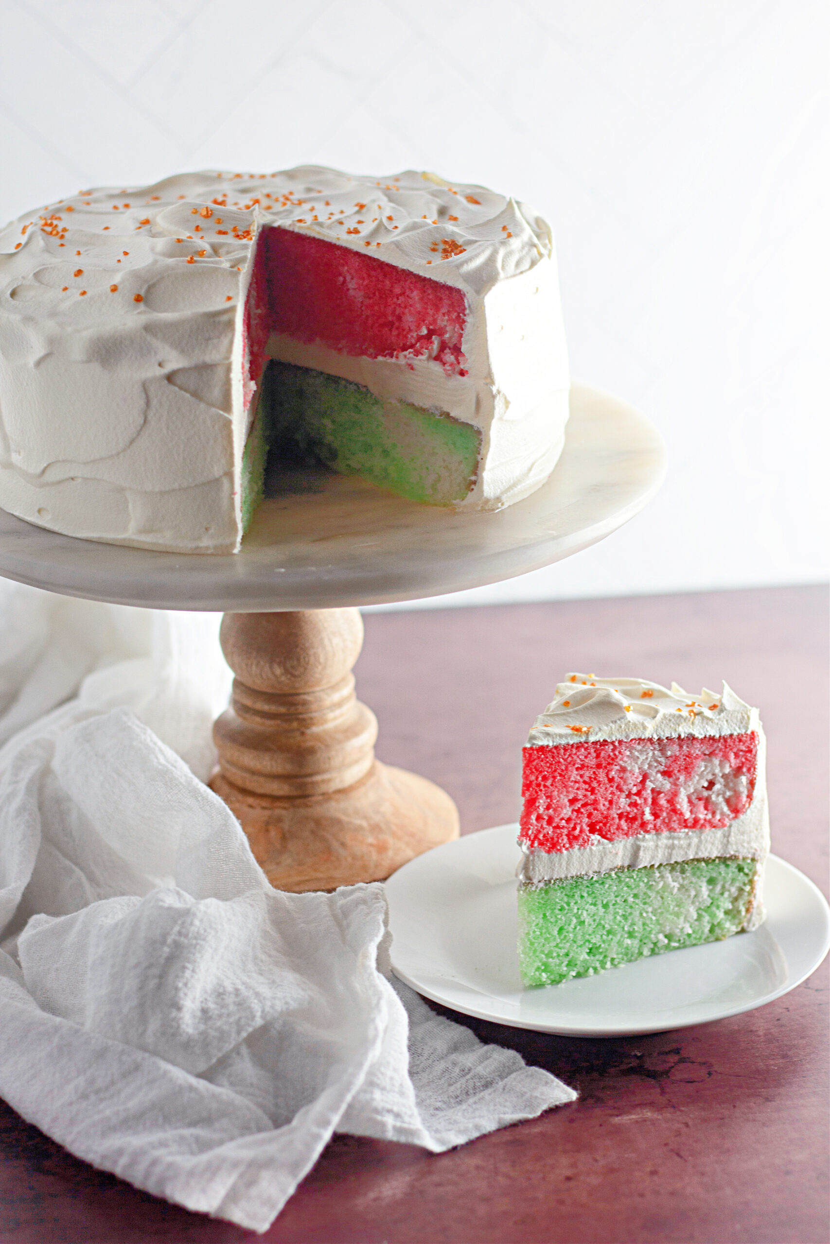Christmas Jello cake on cake stand with slice in front