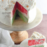 Christmas Jello cake on cake stand with slice on plate