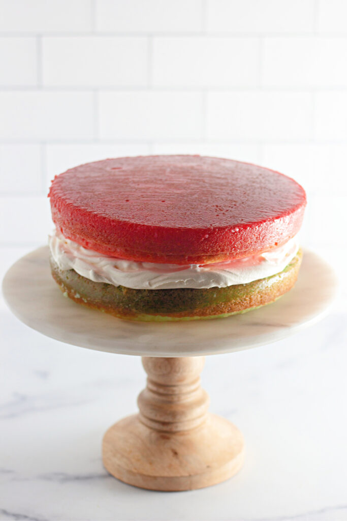 unfrosted layered Jello cake stacked on cake platter