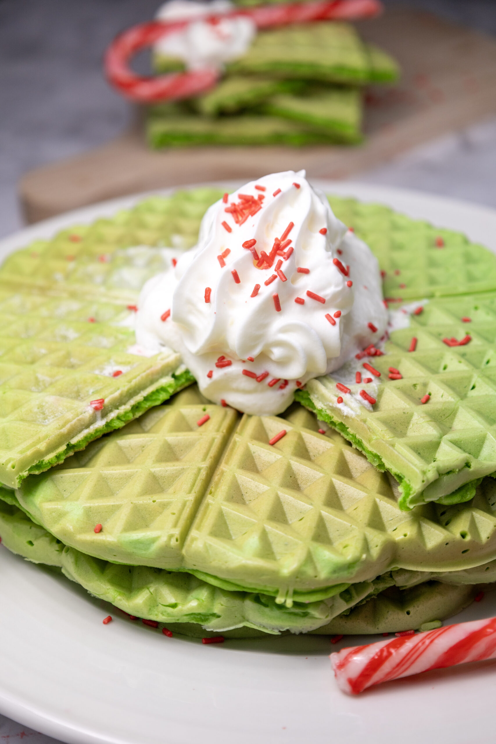 green waffles on plate with sprinkles and whipped cream
