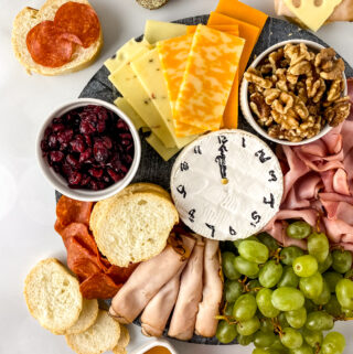 NYE charcuterie board with a cheese clock in center