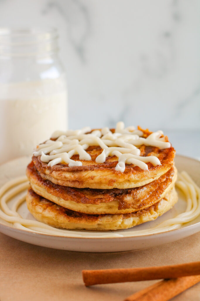 snowflake pancakes on plate with glass of milk at back