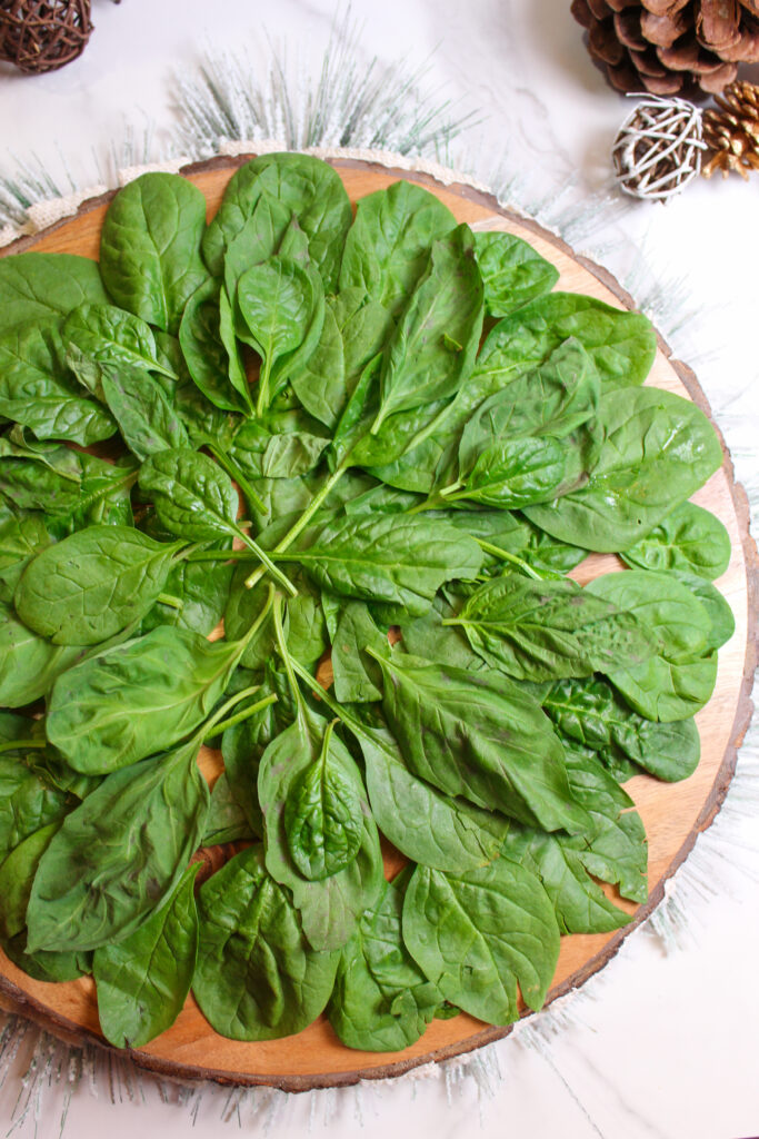 spinach and basil on a wood board