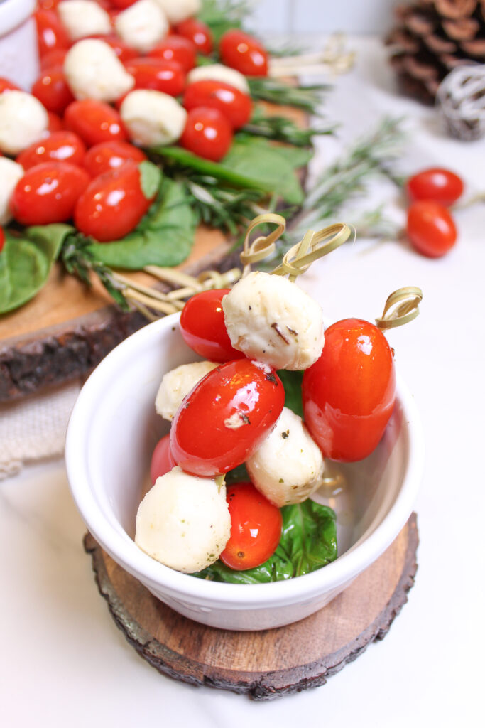 Caprese skewers from a Christmas Caprese skewer wreath salad in a small white bowl