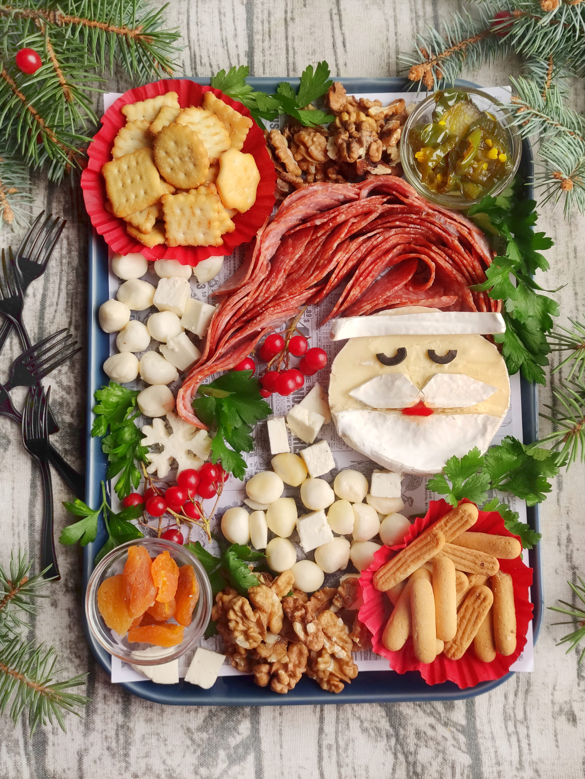 Santa charcuterie board on tray on wooden background with forks