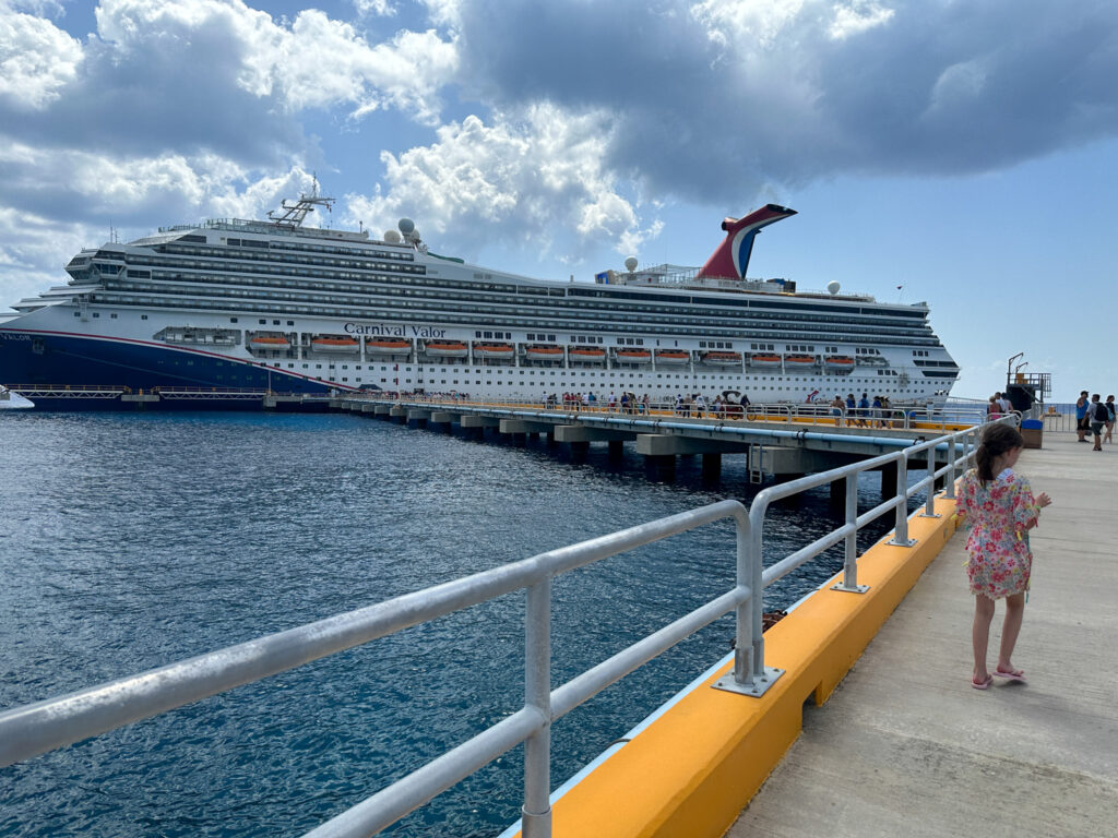 little girl walks in front of Carnival Valor Cruise Ship