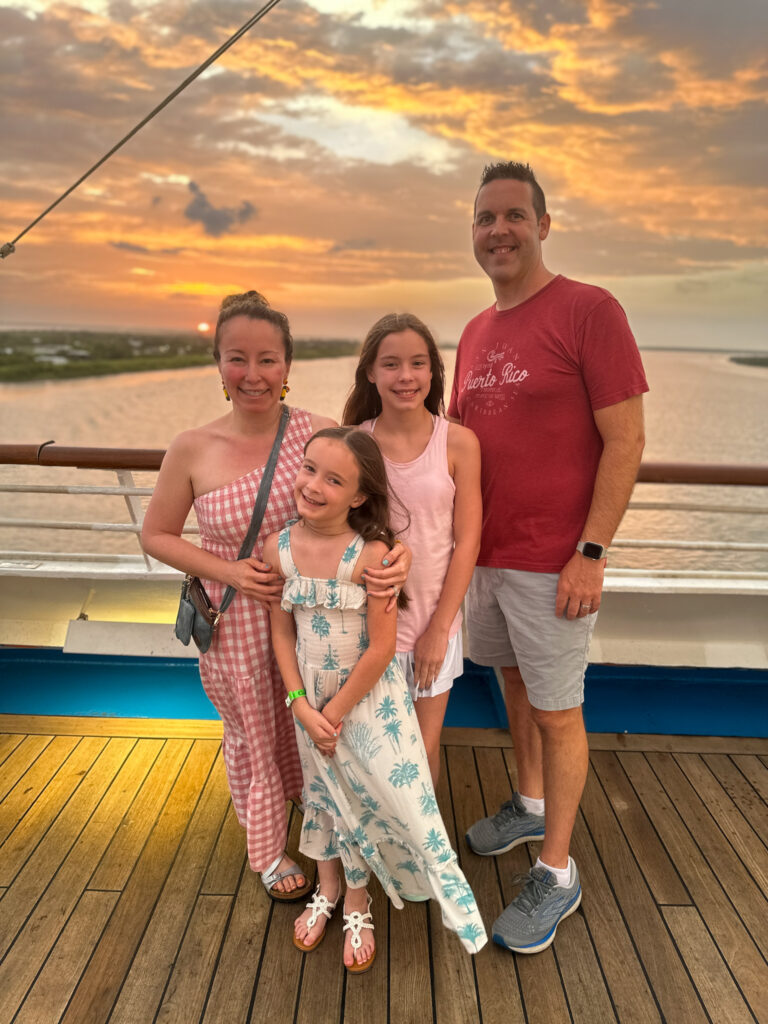 family on Carnival Valor pulling away from New Orleans port at sunset