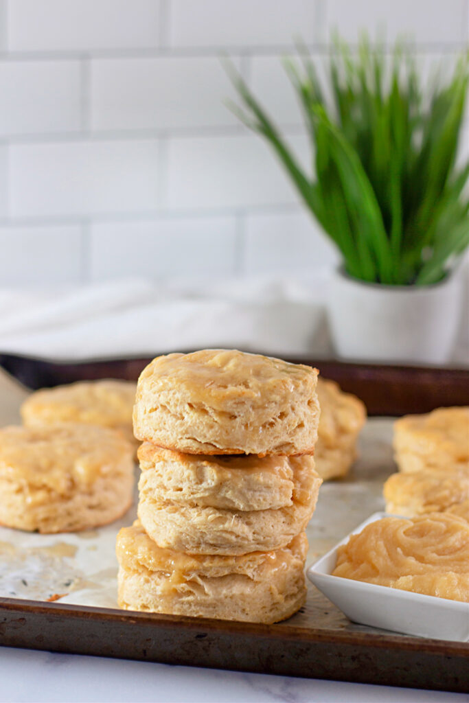 stack of homemade honey butter biscuits on baking sheet