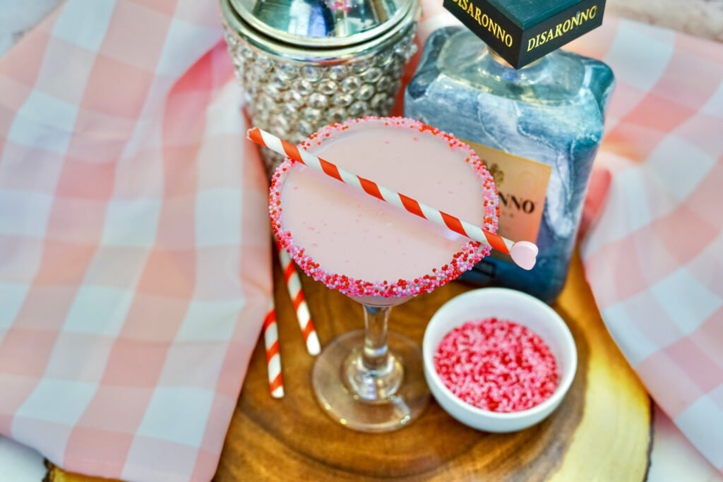 vodka and amaretto pink martini with sprinkles and straw on top