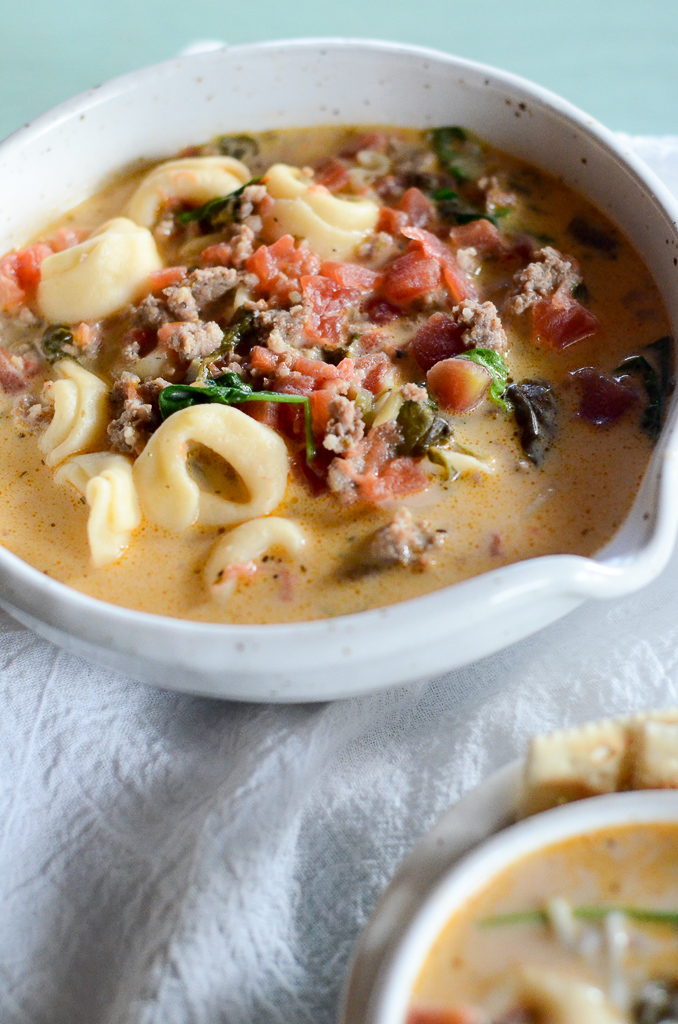 sausage tortellini soup with cream cheese in a white bowl