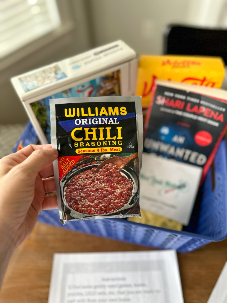 woman holds chili seasoning packet to gift to neighbors during snow storm