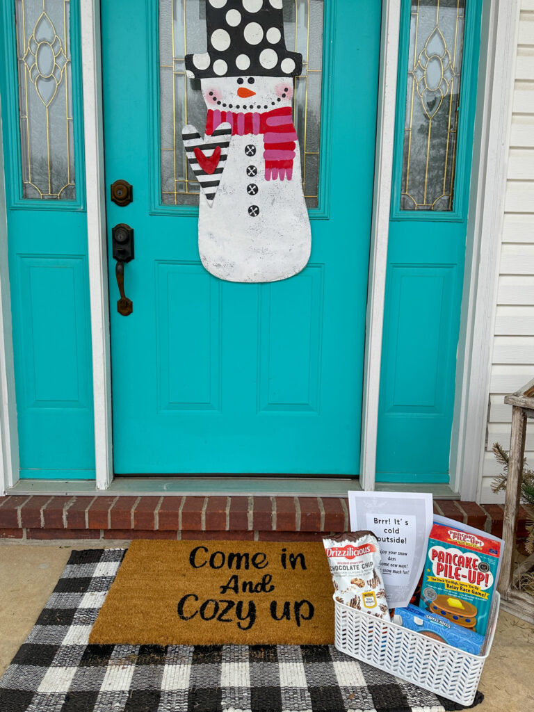 snow box gift - snow day survival kit - on door mat in front of snow mat door sign on turquoise door