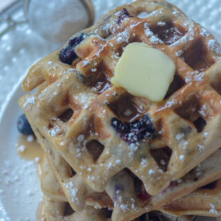 homemade blueberry waffles on a white serving dish