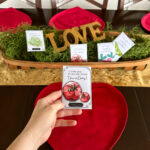 woman holds free Valentine gifts for gardeners in front of table