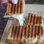 cheese and ham panini sandwich square pulled by man