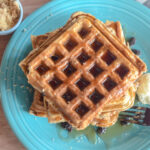 oatmeal raisin waffles on serving plate with striped napkin