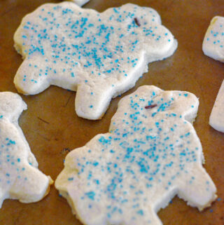 a handful of Easter lamb sugar cookies on a brown baking sheet