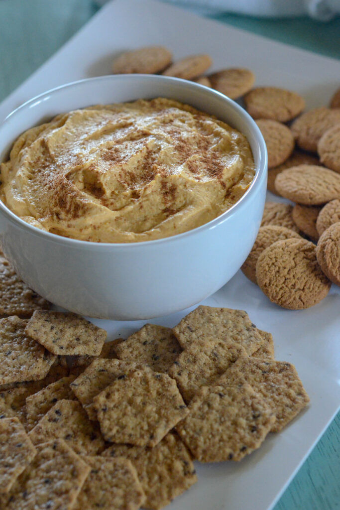 cream cheese pumpkin dip with gingersnaps on white tray