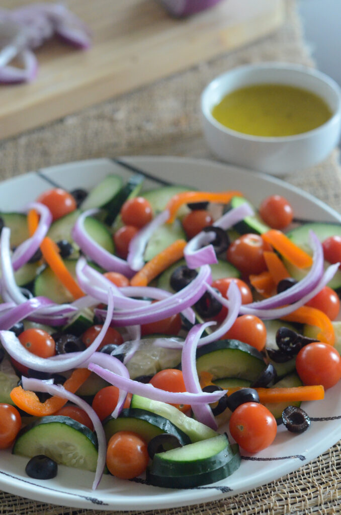 Mediterranean cucumber and tomato salad on striped plate