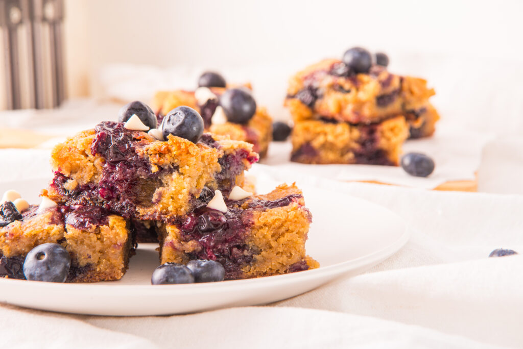 white chocolate blueberry blondies on plates from side angle