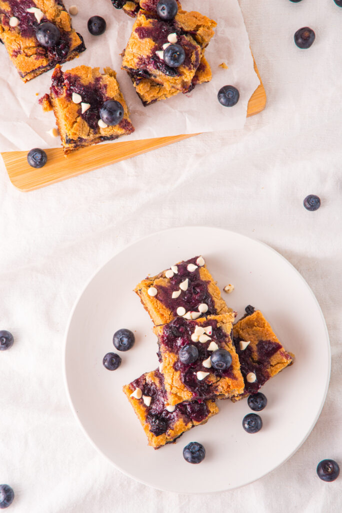 blueberry white chocolate blondies stacked on plate in overhead shot