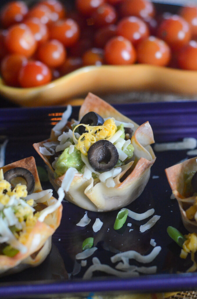 fiesta guacamole wonton cup tacos on purple tray