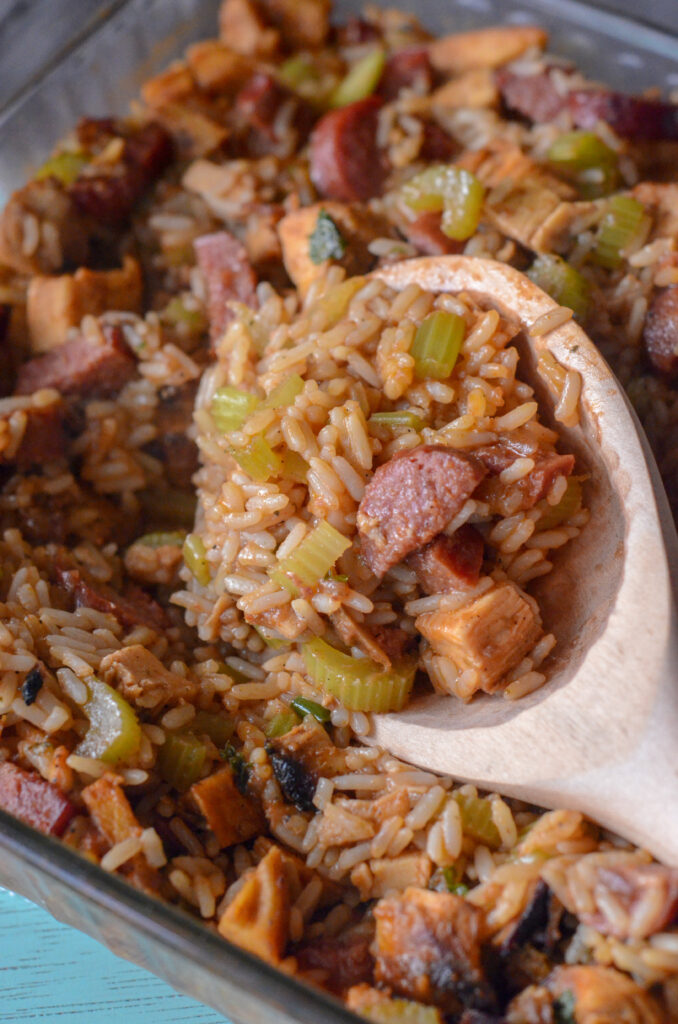 oven jambalaya casserole with smoked sausage and chicken on wood spoon