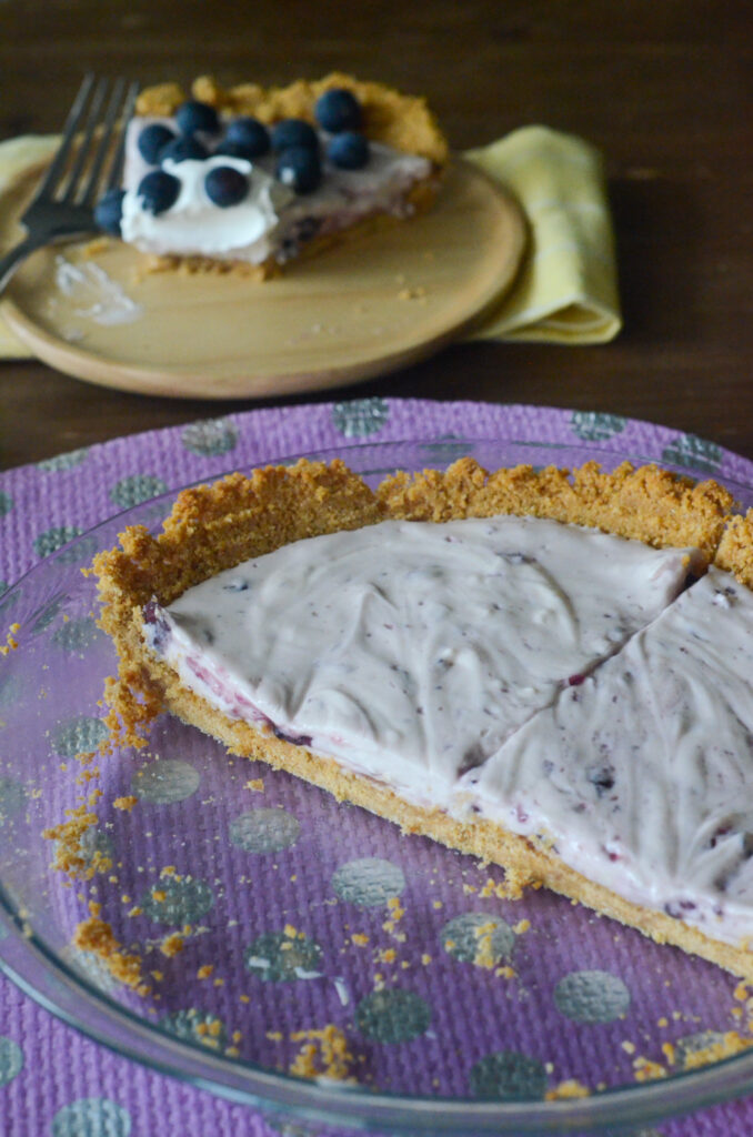 half of a blueberry cream pie in glass pie plate