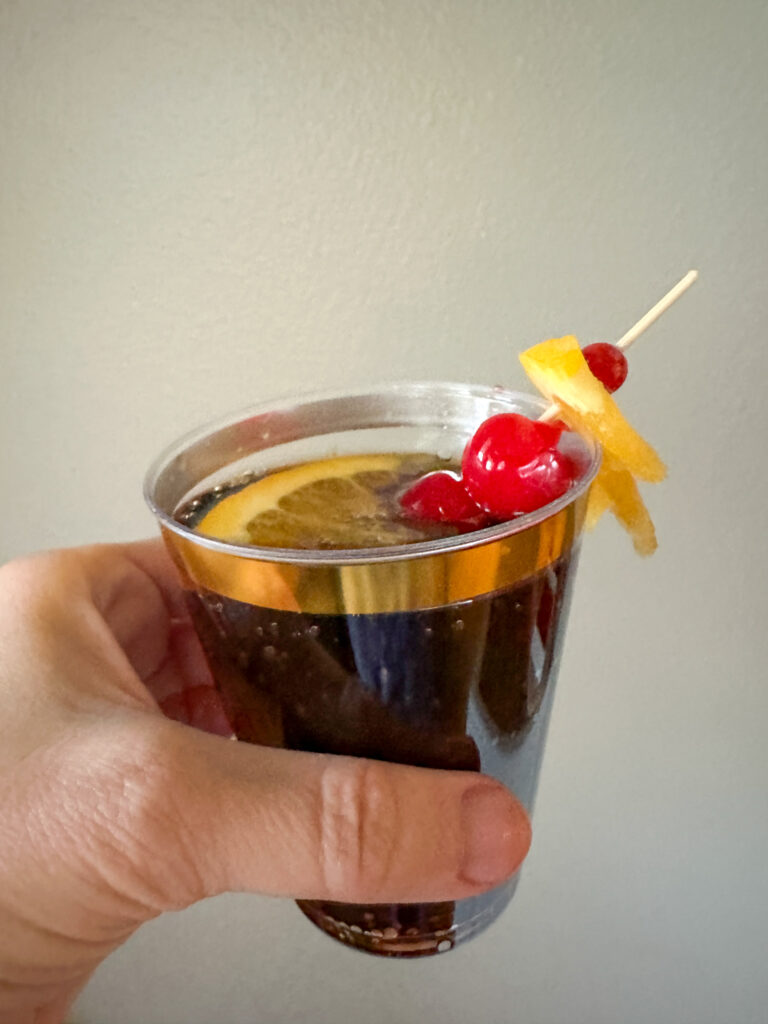 Dr Pepper and rum cocktail - also known as Prohibition Punch in woman's hand