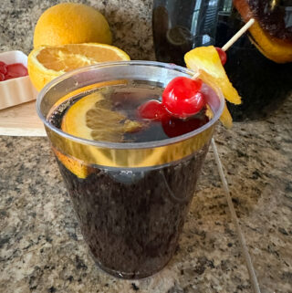 Dr Pepper and rum cocktail - prohibition punch - in glass in front of fruit