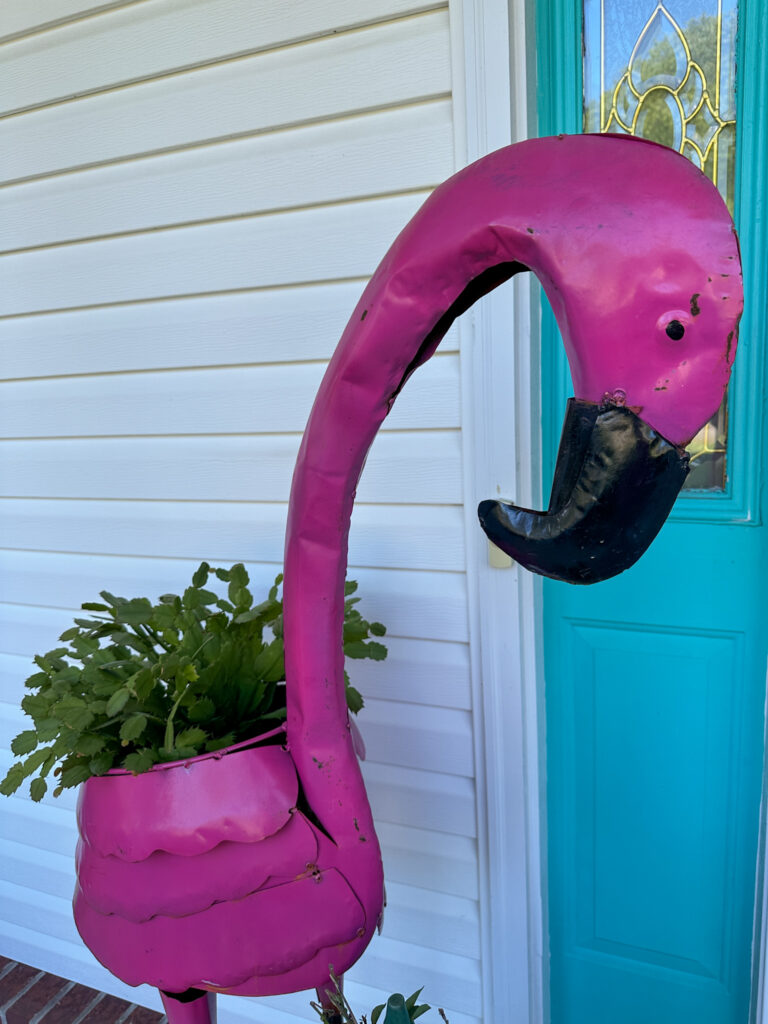 tall pink famingo planter statue flanking a front door