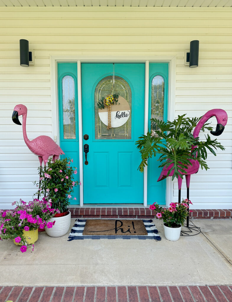 flamingo porch decor flanking turquoise front door with flamingo planter