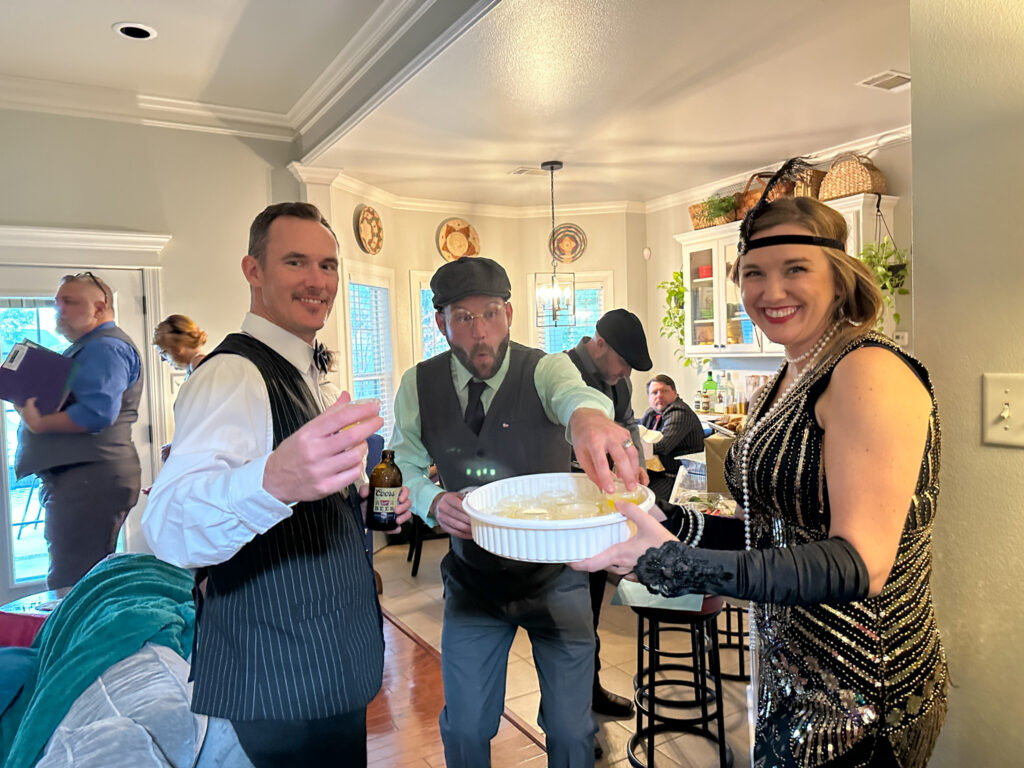 man taking Jello shot from tray for 1920s cocktails ideas and 1920s party food