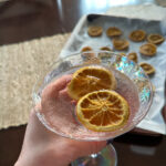 pink lemonade gin cocktail in lady's hand over table